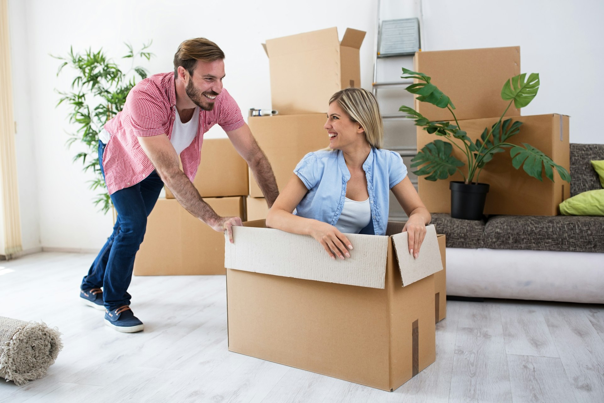 A couple having fun messing around with house moving boxes after renting a property